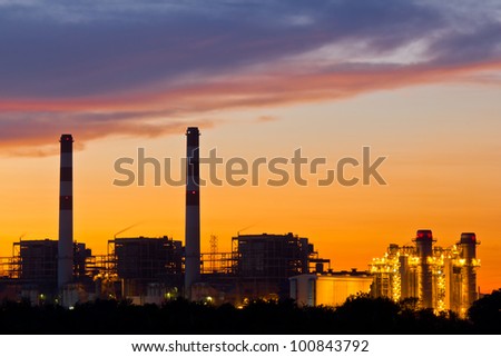 Gas turbine electrical power plant at dusk with orange sky