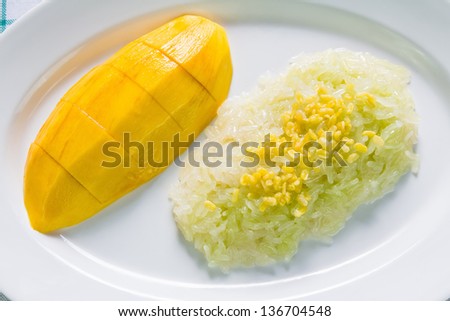 Ripe mango and sticky rice cooked with sweet coconut milk and topping with roast mung bean, Thai traditional dessert