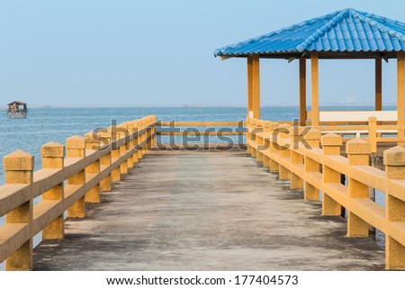 Concrete pier with gazebo and seats at the end of pier in the evening, Thailand