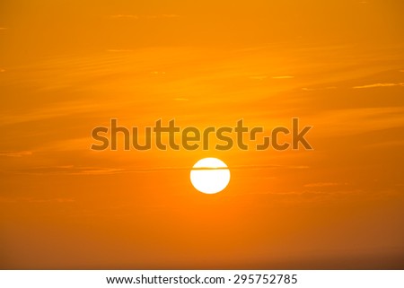 Beautiful sunset sky when there is a thin line of cloud crossing the sun