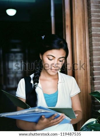 Portrait of an Indian / Asian female student coming out of the examination hall in the campus.