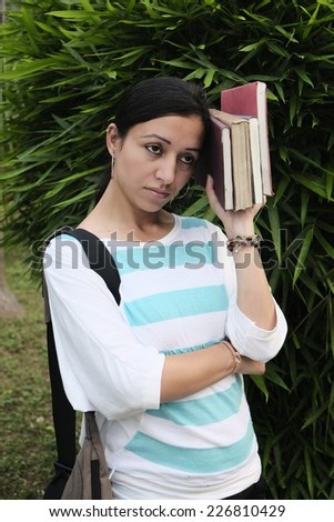 Young indian girl feeling tired  with book in her hand. she is anxious about result or future