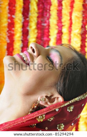 Beautiful Indian girl happily smiling. Side pose of an Indian lady with closed eyes  and laughing in happiness.