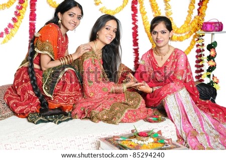 Festival celebrations in India by applying mehendi/henna. Traditional Indian ladies celebrating colors of india.