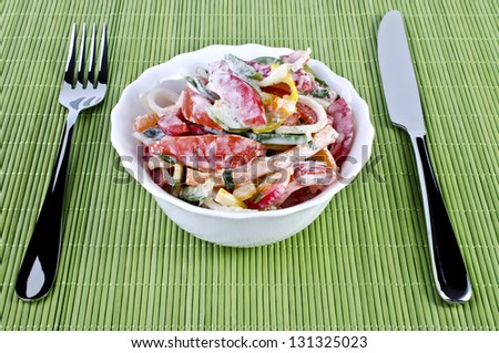 Tableware - a delicious summer salad with a fork and knife on the sides