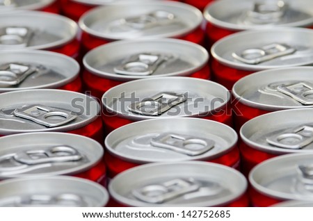 Many aluminum red cans of soft drink cola close-up