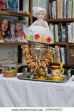 KERCH, CRIMEA, RUSSIA - FEBRUARY 22: A doll sits on top of the samovar where bagels are hung in the library of Ostrovsky during the celebration of carnival on February 22, 2015 in Kerch, Crimea, Russia