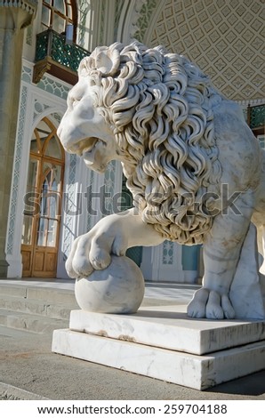 Architectural landmark - Sculpture of a lion of white marble with ball in the Vorontsov Palace in Alupka, Yalta, Crimea