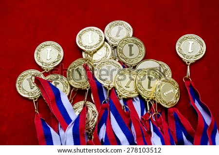 Many gold medals with tricolor ribbons close-up. Medal for first place in the competition