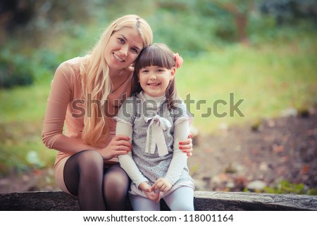 happy young mother with the daughter in park