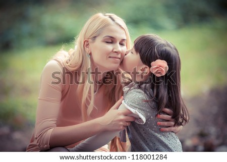 happy young mother with the daughter in park