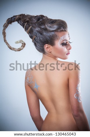 portrait of nude girl body painted with silver drawings