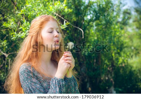 portrait of the rural red-haired girl with a dandelion