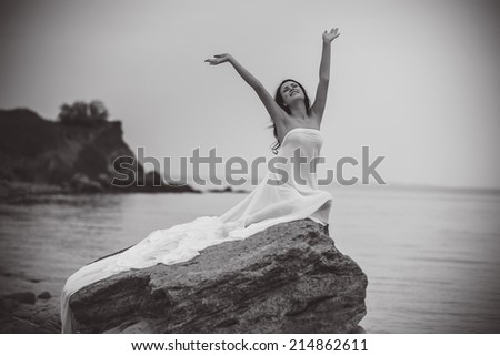 Attractive woman in white fabric on the rock