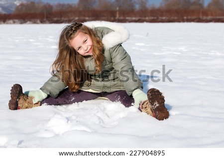 Happy child sit down in the snow