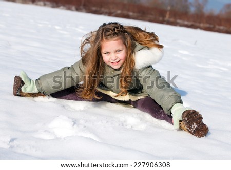 Happy child sit down in the snow