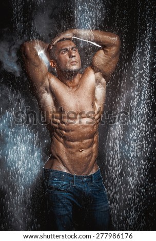 very muscular handsome athletic man in the rain