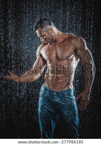 very muscular handsome athletic man in the rain