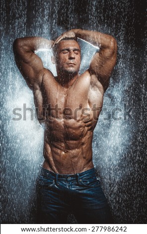 very muscular handsome athletic man in the rain