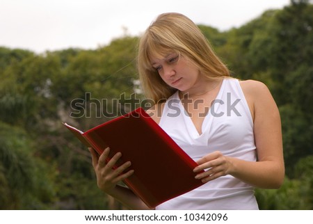 The girl on the nature with a writing-book