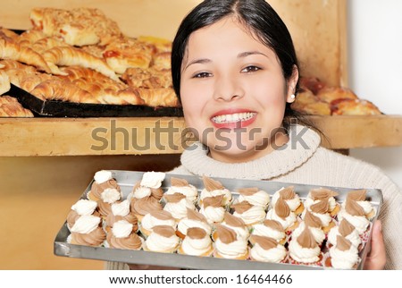 The pleasant saleswoman with sweets in hands