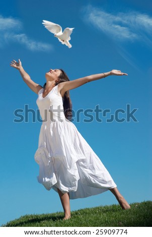 The happy woman releasing a pigeon in sky