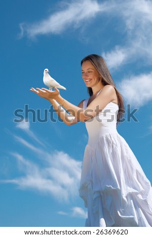 The happy woman releasing a pigeon in sky