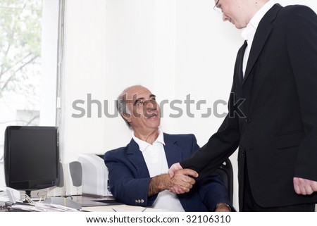 The elderly businessman with young colleague on a workplace