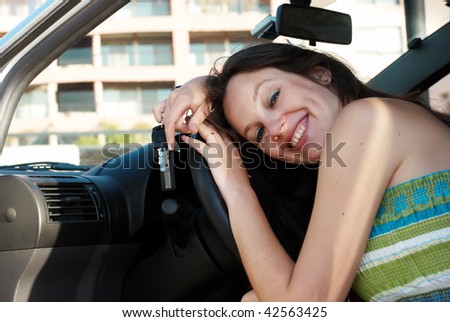 The happy woman in just bought car