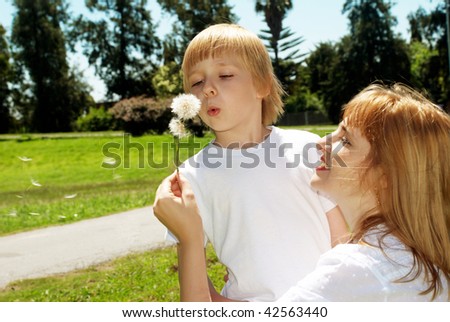 Mother with the son with dandelions in hands