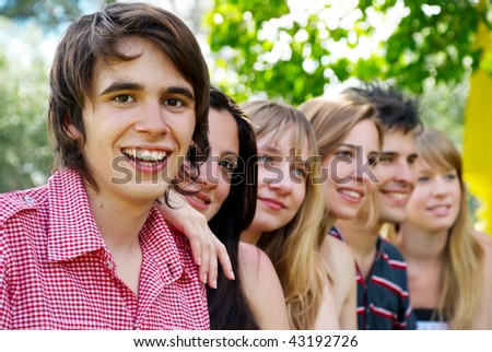 Portrait of a beautiful young guy and friends group