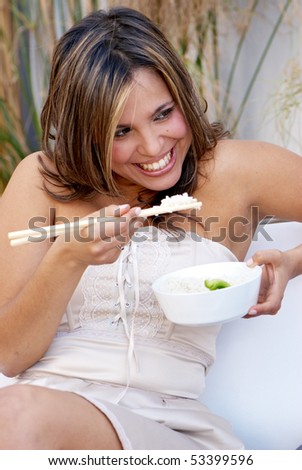 Beautiful woman eating rice with sticks