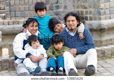 Happy Latin family sitting in the street