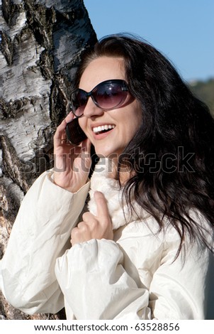 Closeup portrait of a smiling young beautiful woman talking on cellphone