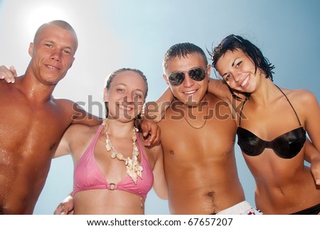Happy group of friends smiling at the beach