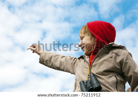 The boy drawing a chalk on cloudy sky