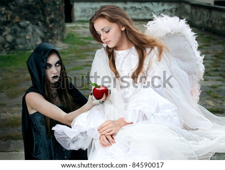 witch and angel against the walls of the old castle