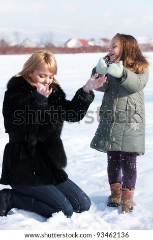 Young mother and her little daughter enjoying beautiful winter day outdoors