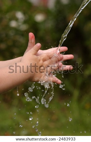 Children\'s hands under a jet of water