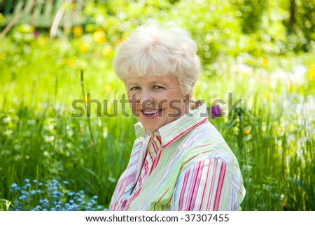Portrait of the smiling elderly woman in  a garden