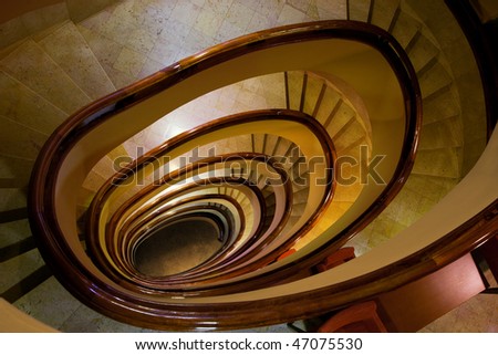 Old marble spiral stairs with wooden handrails