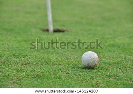 old golf ball on the green with the hole