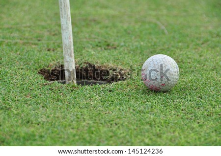 old golf ball on the green with the hole