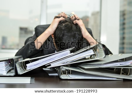 businessman at office desk overloaded with work.