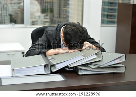 businessman at office desk overloaded with work.