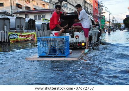 BANGKOK - OCTOBER 30: Unidentified people sit and stand in big truck to escape rising flood waters at Donmuang, in Bangkok, Thailand on Oct. 30, 2011