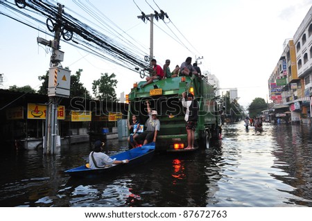 BANGKOK - OCTOBER 30: Unidentified people sit and stand in big truck to escape rising flood waters at Donmuang, in Bangkok, Thailand on Oct. 30, 2011