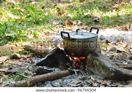 Preparing food on campfire in wild camping