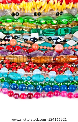 Lot of colored beads from different minerals and stone background