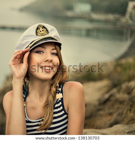 Adorable woman wearing sea Captain's cap and sexy sailor T-shirt